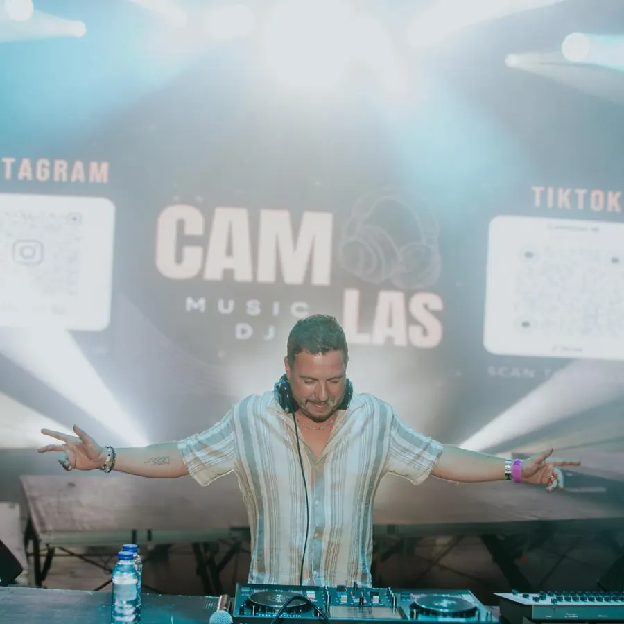 Camolas DJ em palco com luzes e o logótipo no ecrã